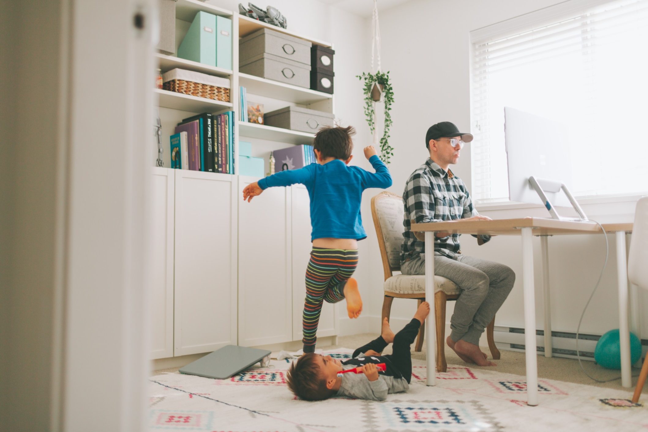 young father working from home while his kids play next to him